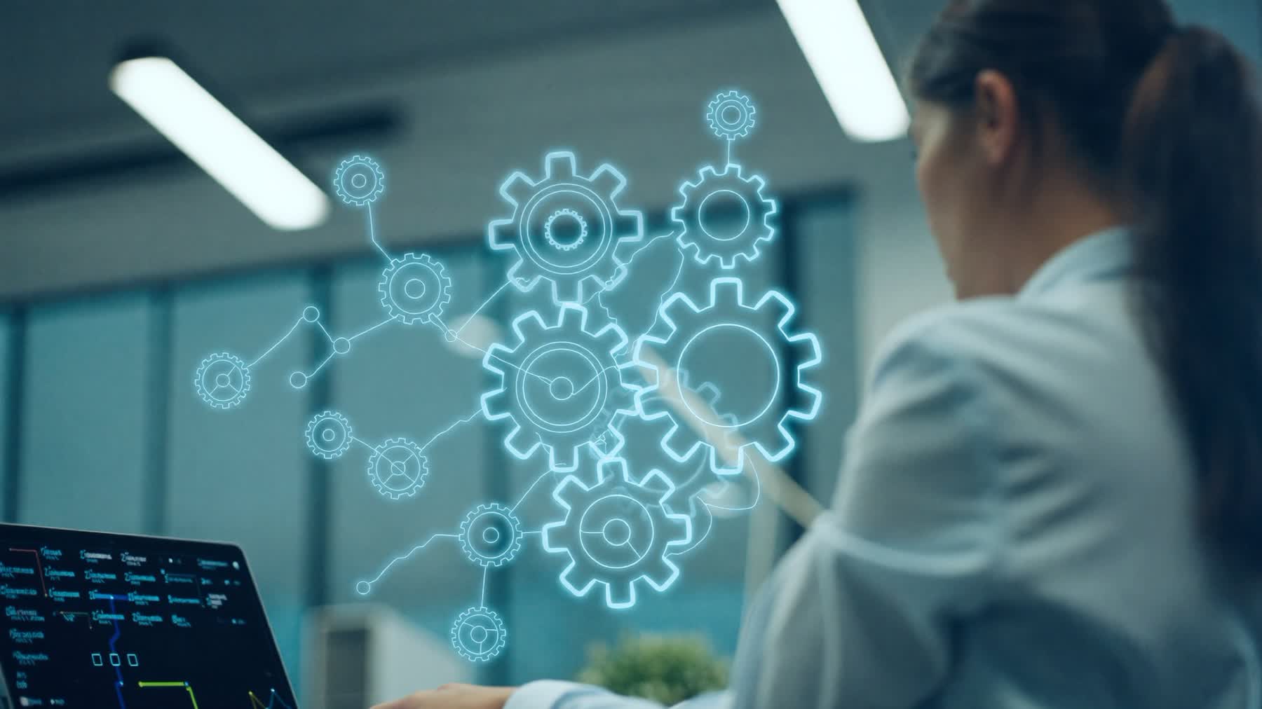 Fachkraft am Laptop mit leuchtendem Zahnrad-Netzwerk als Symbol für Managementsysteme
