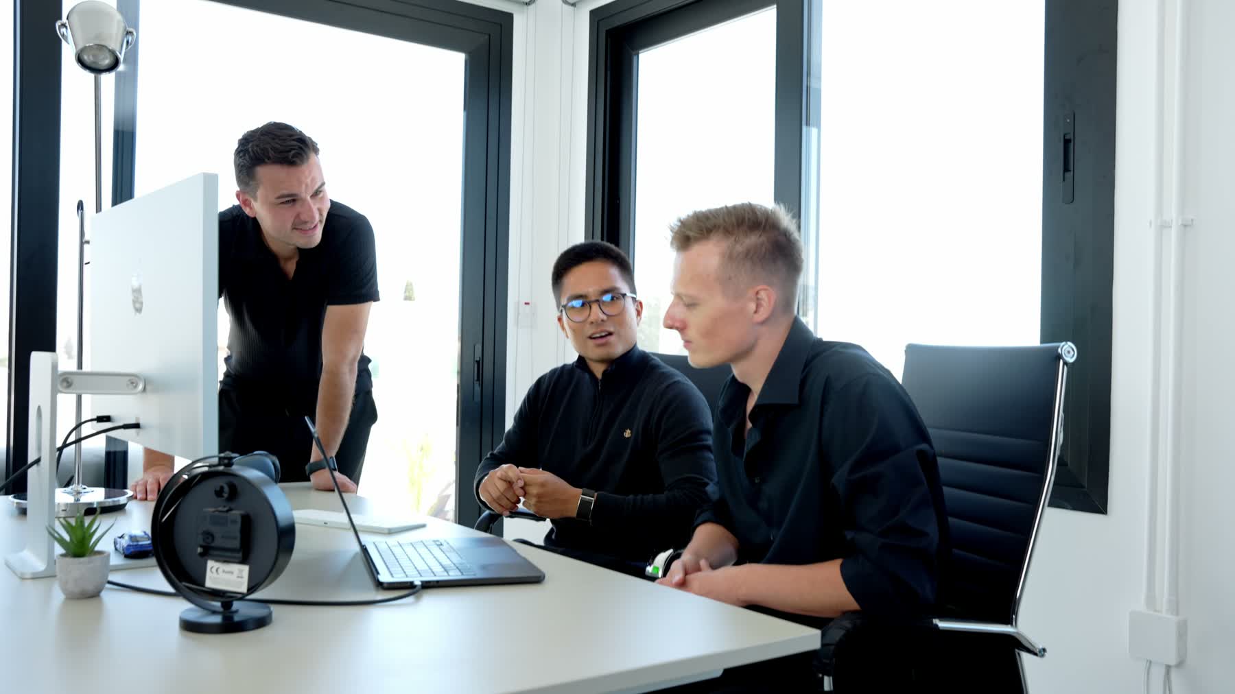 Teammitglieder im Gespräch am Schreibtisch im Büro
